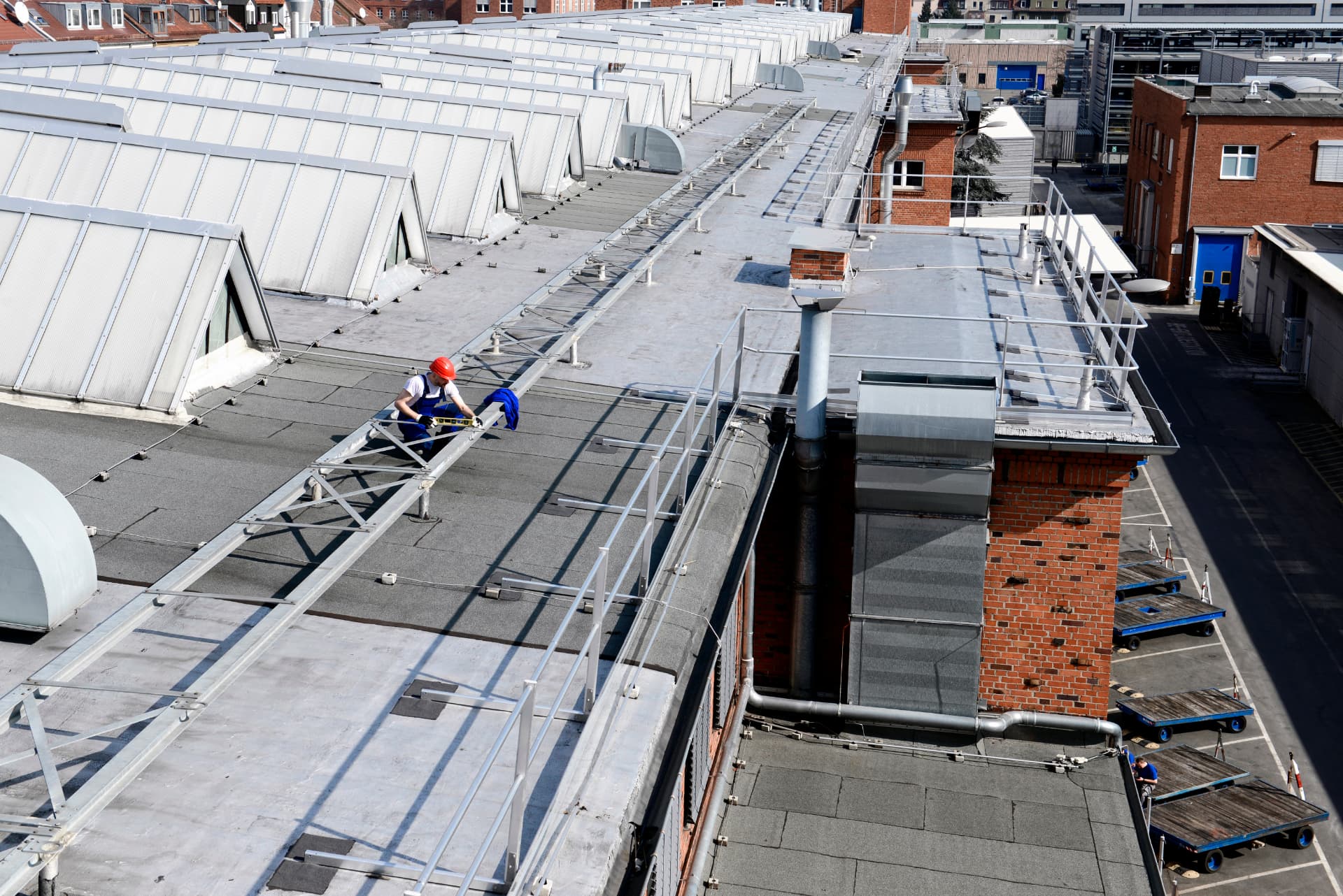 Monteur werkt aan een valbeveiligingssysteem op een industrieel dak